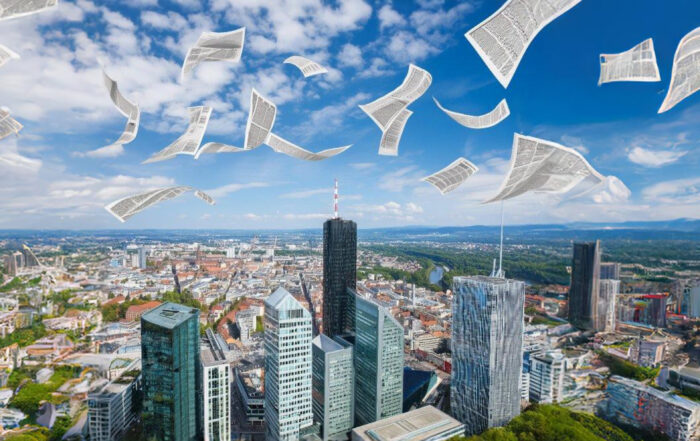 Blick über die Hochhäuser von Frankfurt mit Zeitungen als Symbol für Unternehmenspräsenz in den Medien