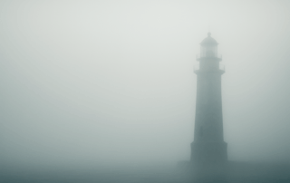 Leuchtturm im dichten Nebel mit freier Fläche auf der linken Seite