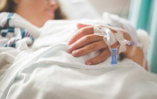 Patientin liegt in einem Klinikbett und erhält medizinische Versorgung