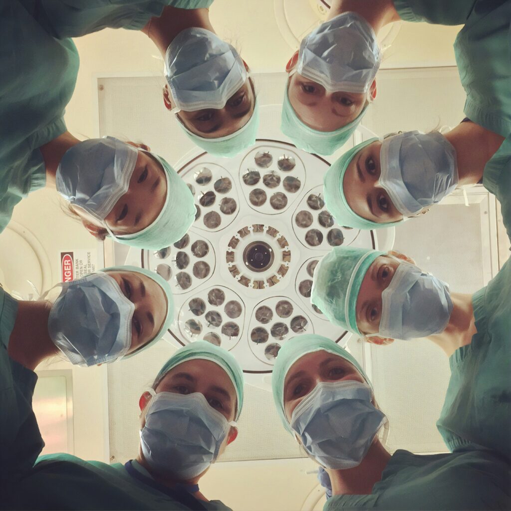 Ärzt:innen und Pflegekräfte blicken aus der Perspektive eines Patienten nach unten