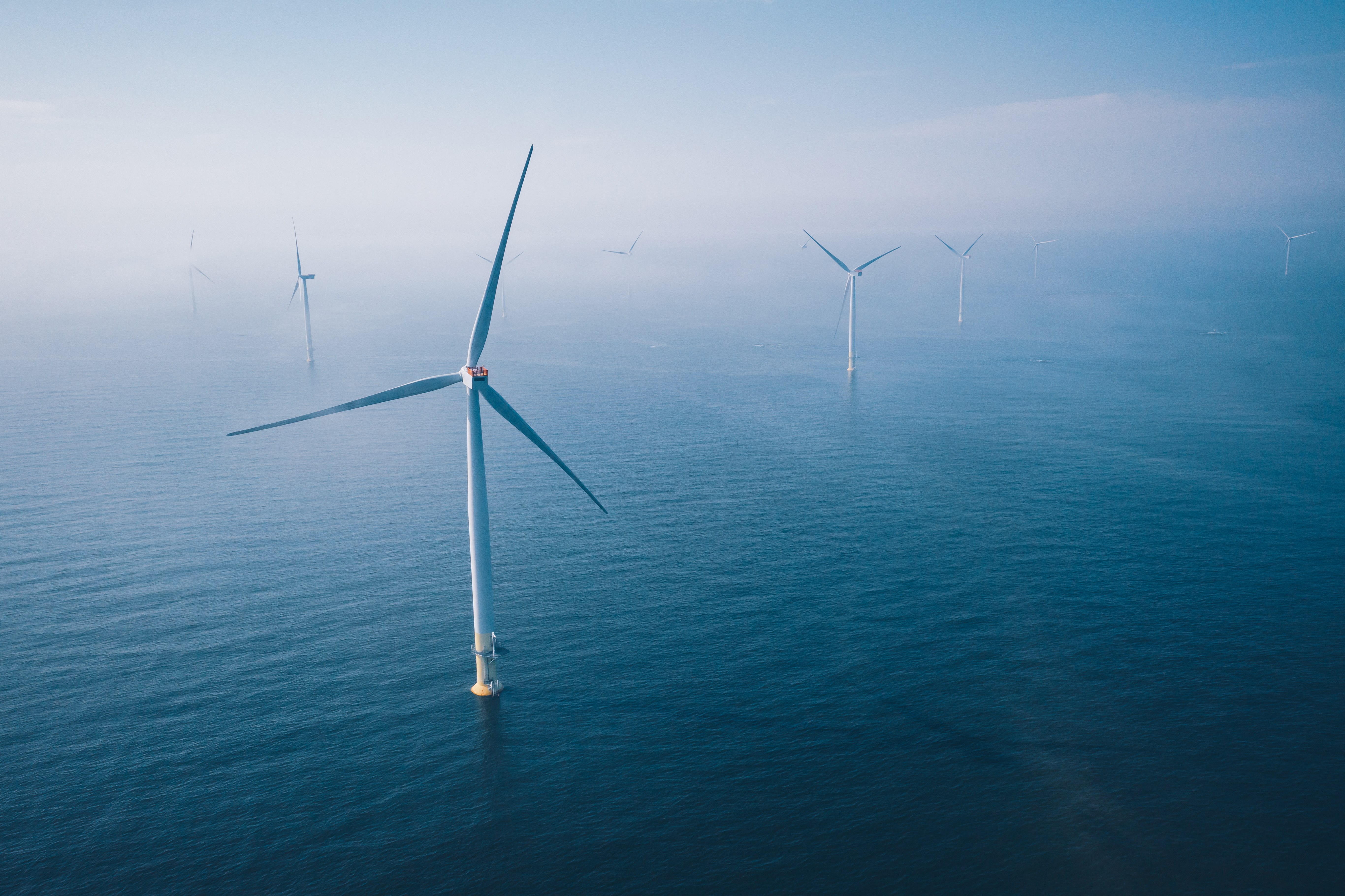 Windkraftanlage. Luftaufnahme eines Windparks mit Windturbinen im blauen Meer in Finnland.