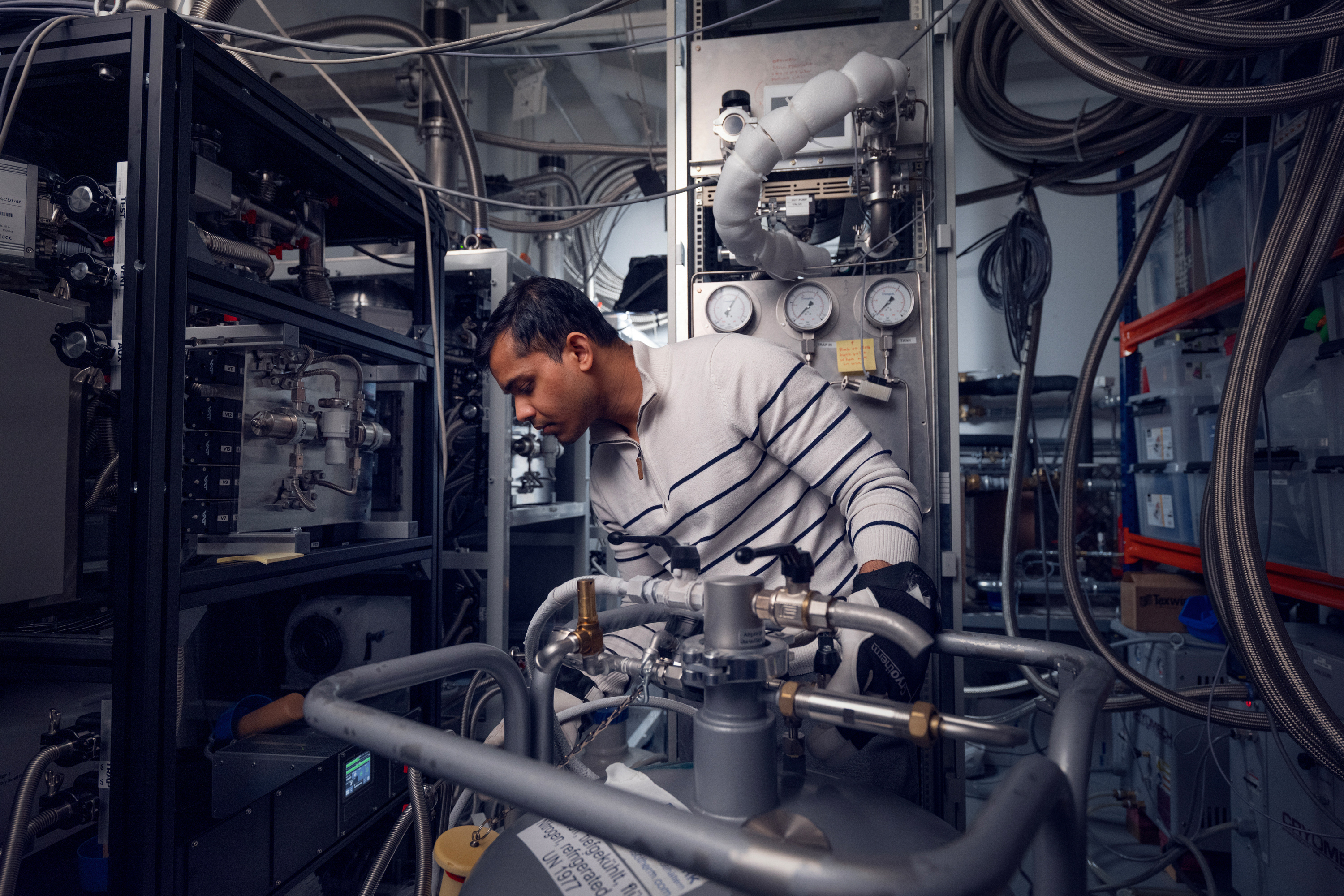 Forscher arbeitet an technischer Anlage für Quantencomputing im Labor Forscher arbeitet an technischer Anlage für Quantencomputing im Labor
