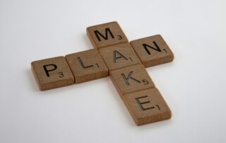 Holzbuchstaben mit den Wörtern „PLAN“ und „MAKE“ als Symbol für strategische Kommunikation und Umsetzung